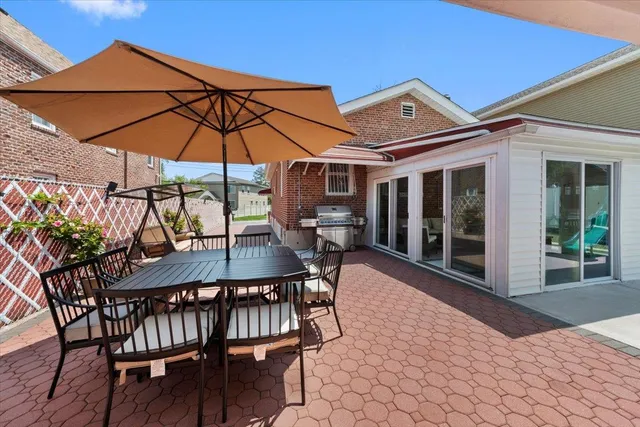 a view of a patio with table and chairs under an umbrella