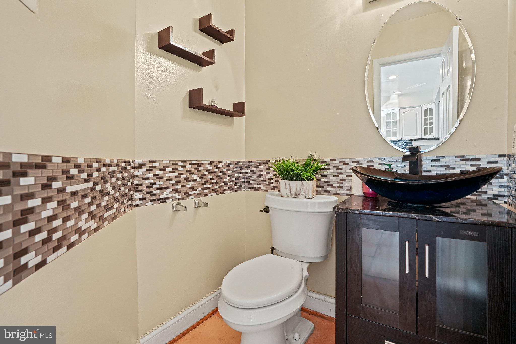 14902 Ashford Place Laurel, MD 20707 - Photo 18 of 41 a bathroom with a toilet a sink and a mirror