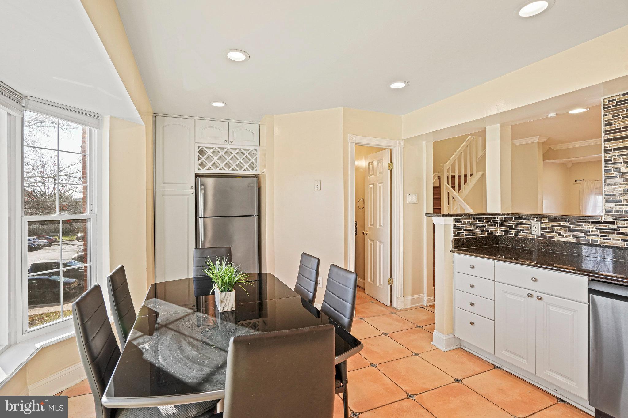 14902 Ashford Place Laurel, MD 20707 - Photo 22 of 41 a living room with furniture a large window and dining table