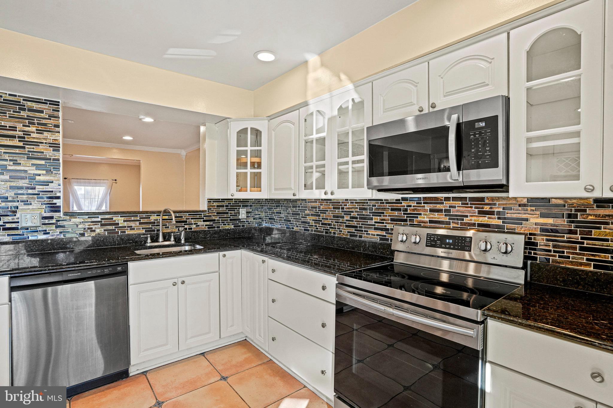 14902 Ashford Place Laurel, MD 20707 - Photo 24 of 41 a kitchen with stainless steel appliances a sink stove and microwave