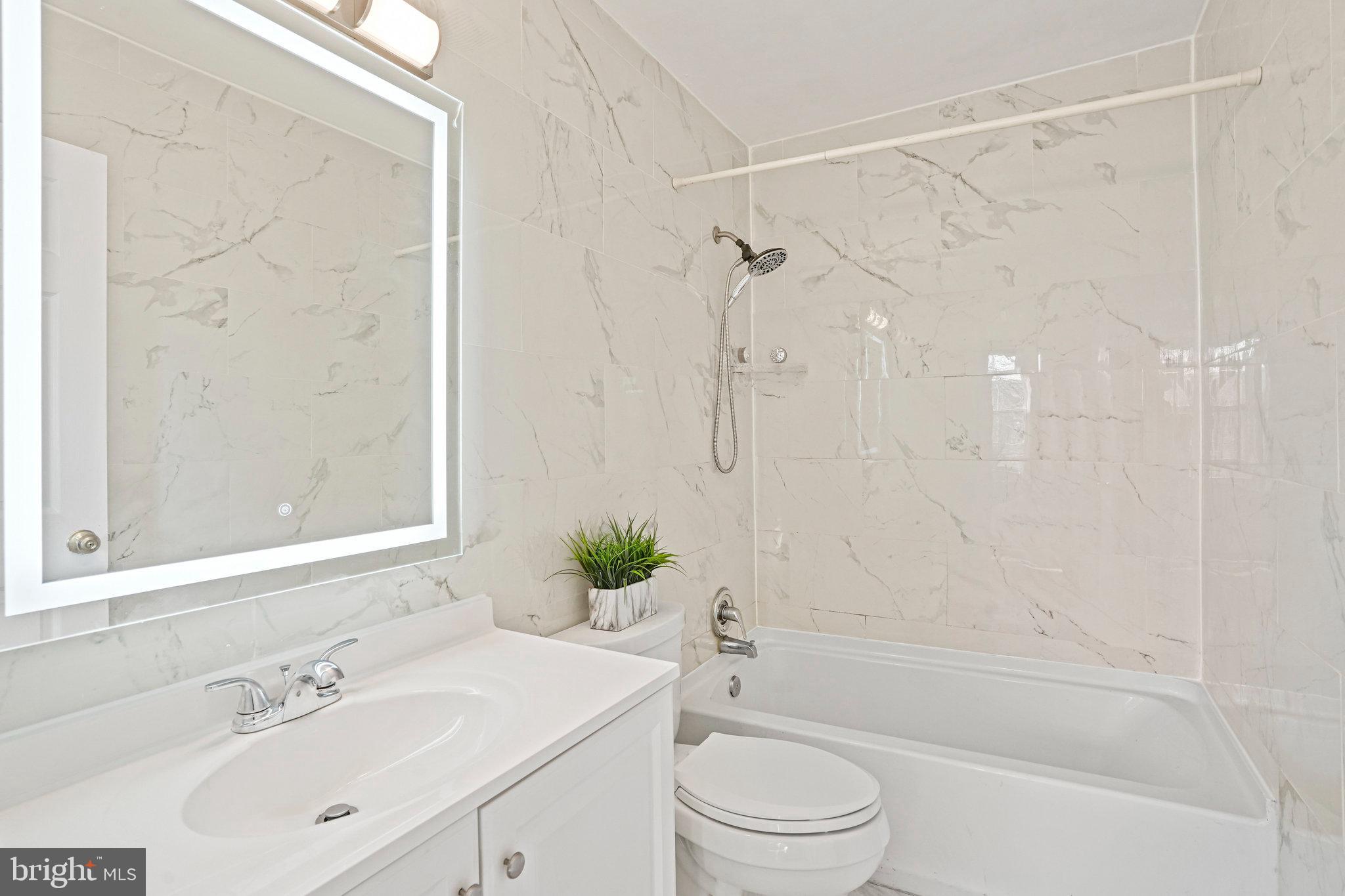 14902 Ashford Place Laurel, MD 20707 - Photo 28 of 41 a bathroom with a bathtub shower sink vanity and toilet