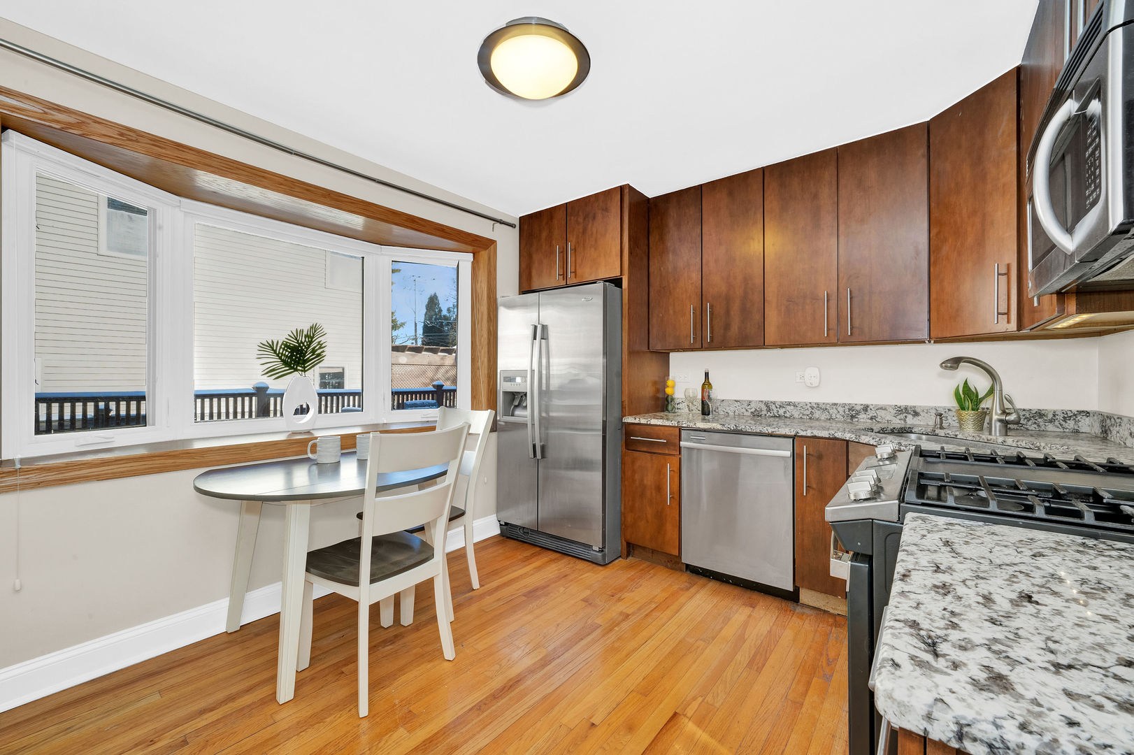 617 South Western Avenue Park Ridge, IL 60068 - Photo 11 of 40 a kitchen with stainless steel appliances granite countertop a refrigerator a stove top oven a sink dishwasher and white cabinets with wooden floor