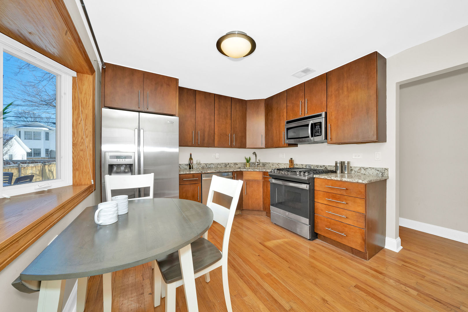 617 South Western Avenue Park Ridge, IL 60068 - Photo 13 of 40 a kitchen with stainless steel appliances granite countertop a stove a refrigerator a microwave oven with a dining table and chairs with wooden floor