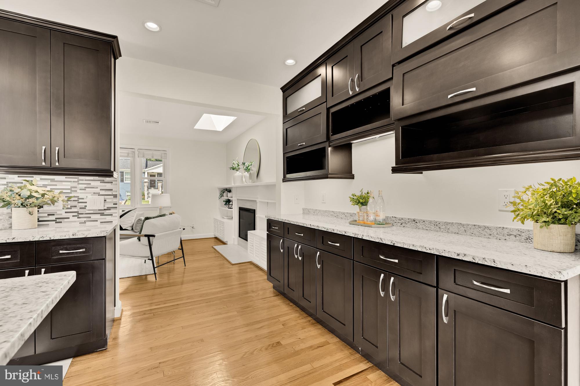 8921 Whitney Street Silver Spring, MD 20901 - Photo 5 of 27 a kitchen with stainless steel appliances kitchen island granite countertop a stove a sink dishwasher and a microwave oven with wooden cabinets