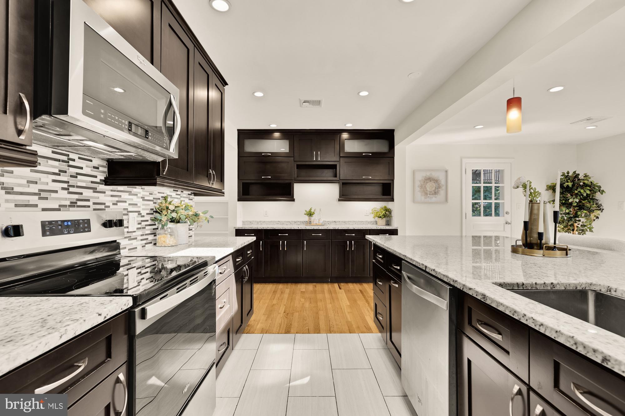 8921 Whitney Street Silver Spring, MD 20901 - Photo 9 of 27 a kitchen with stainless steel appliances granite countertop a sink and a stove