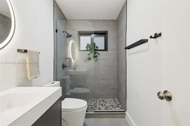a bathroom with a sink a toilet and shower