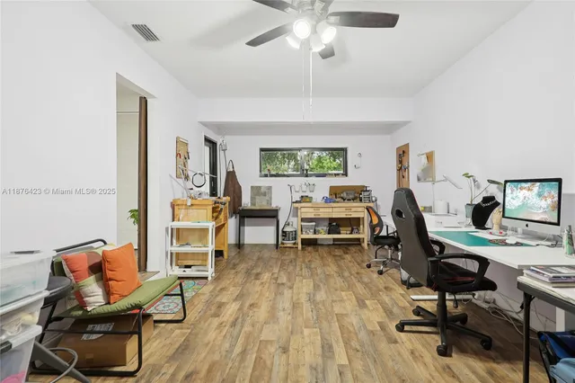 a view of a workspace with wooden floor and a window