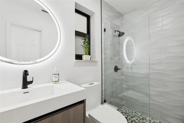 a bathroom with a sink a toilet and shower