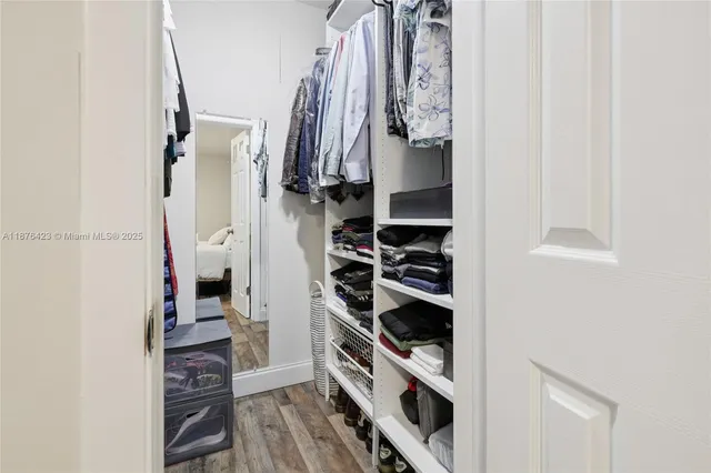 a view of walk in closet with clothes and shoes
