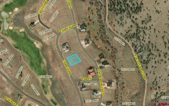 a view of a green field with trees in the background