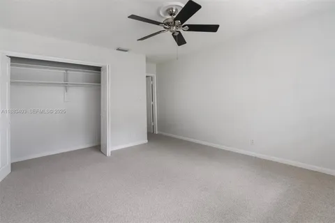 an empty room with a ceiling fan and a window