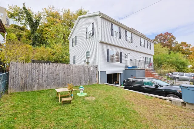 a front view of a house with a garden and a bench