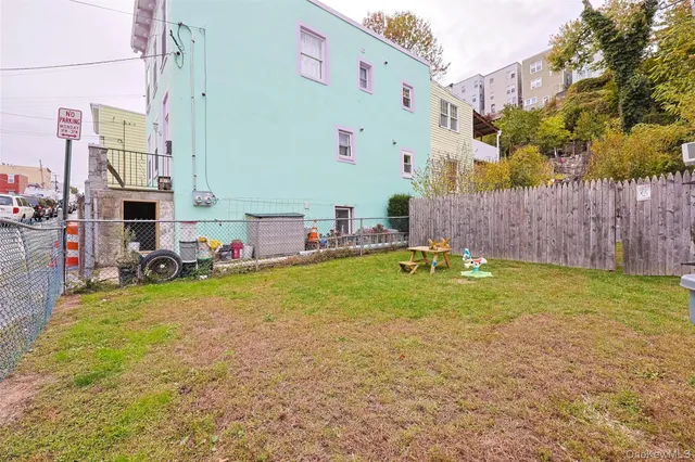 a view of a backyard with table and chairs and wooden fence