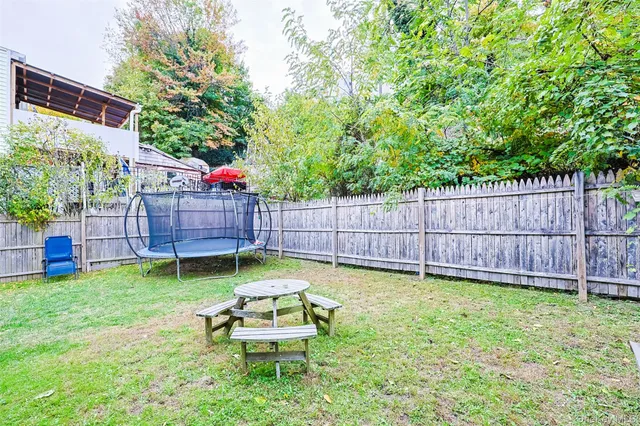 a view of a backyard with table and chairs and wooden fence