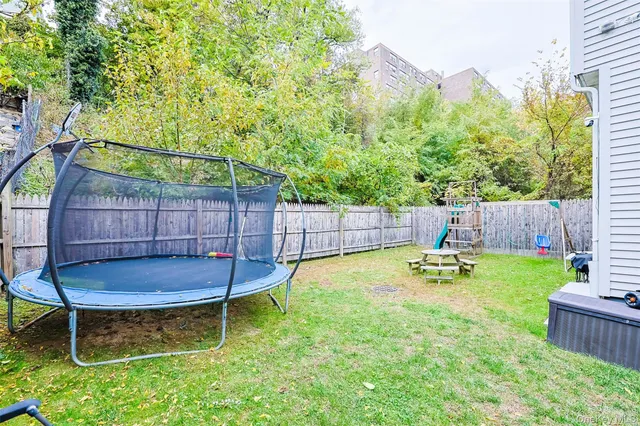 a view of a backyard with a large tree and wooden fence