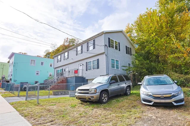 a front view of a house with a garden and parking space