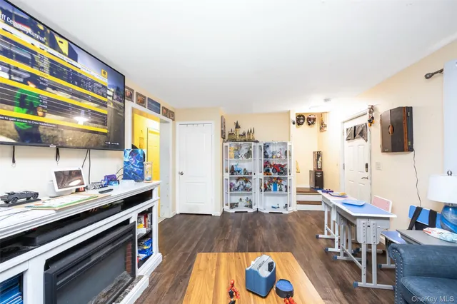 a living room with stainless steel appliances furniture and a wooden floor