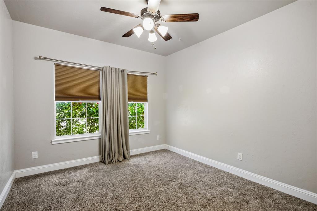 1502 Reed Street Greenville, TX 75401 - Photo 20 of 26 Carpeted room featuring light gray walls, white baseboards, and a ceiling fan with light fixture