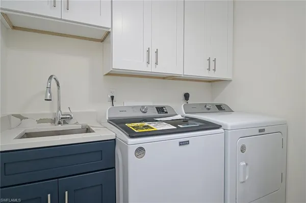 a utility room with sink dryer and washer