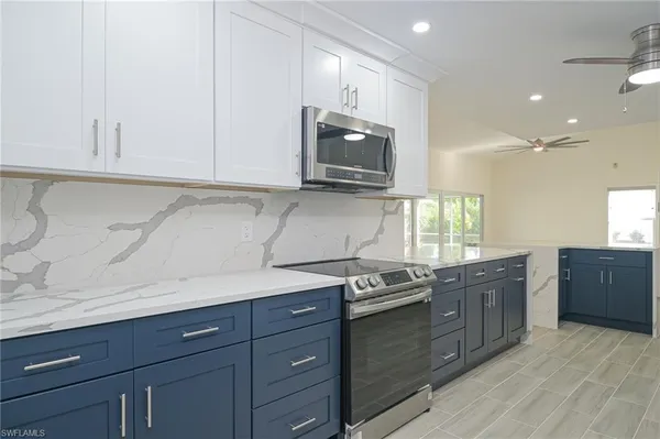 a kitchen with stainless steel appliances granite countertop a sink a stove and a microwave