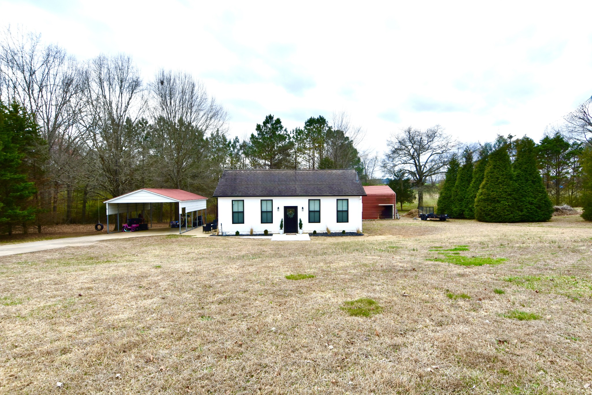 a front view of a house with a yard and trees