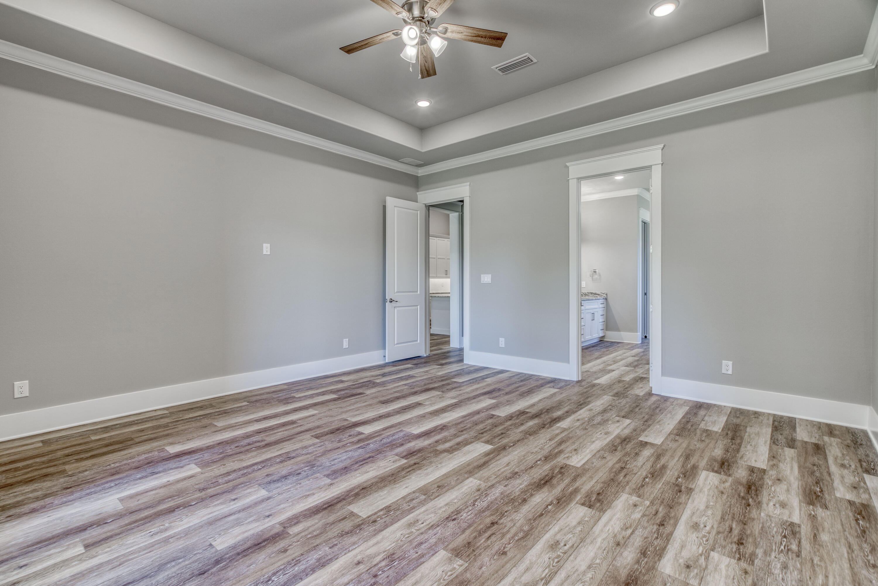 2864 P.G.A Boulevard Navarre, FL 32566 - Photo 17 of 52 a view of an empty room with wooden floor and chandelier fan