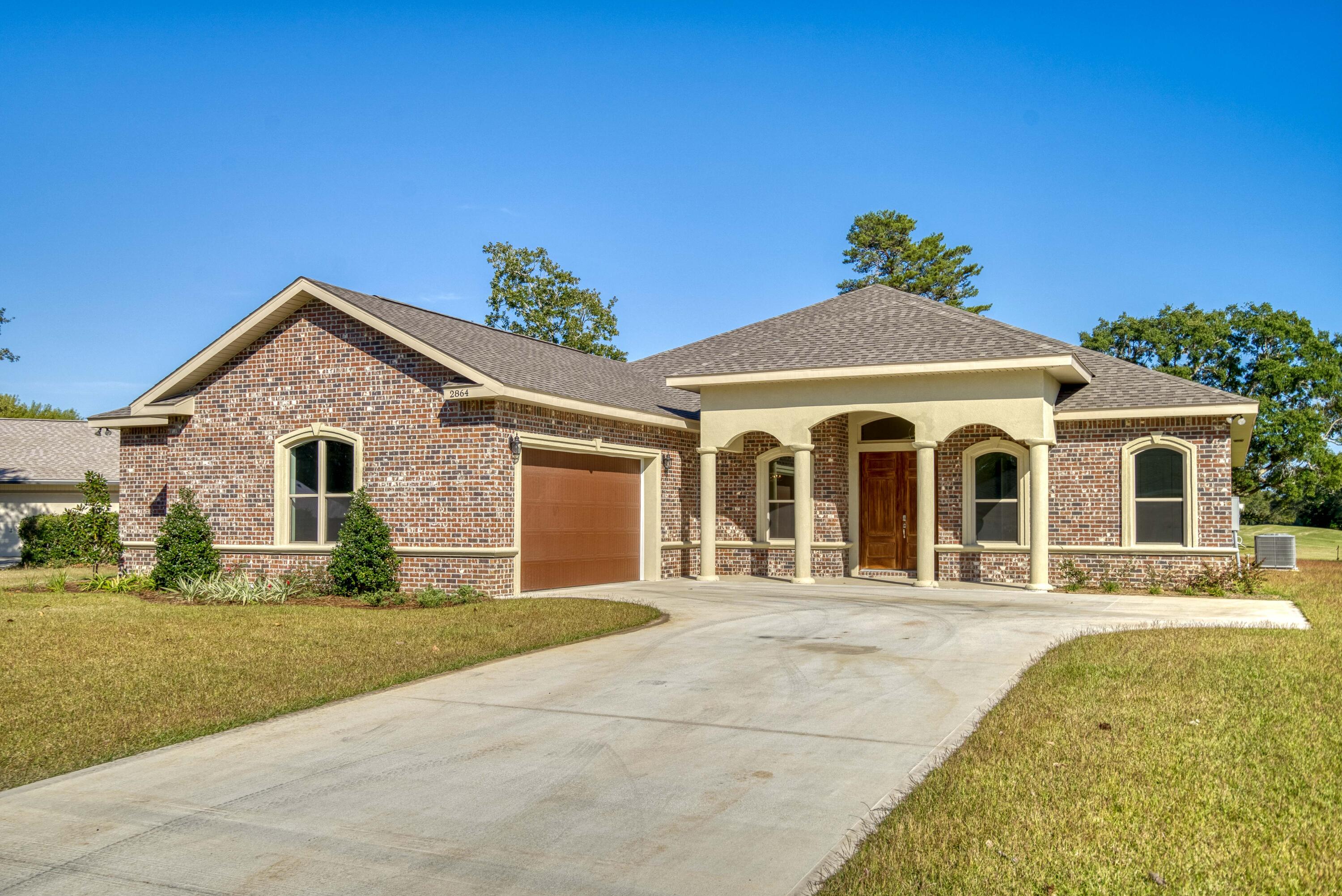 2864 P.G.A Boulevard Navarre, FL 32566 - Photo 3 of 52 a front view of a house with a yard