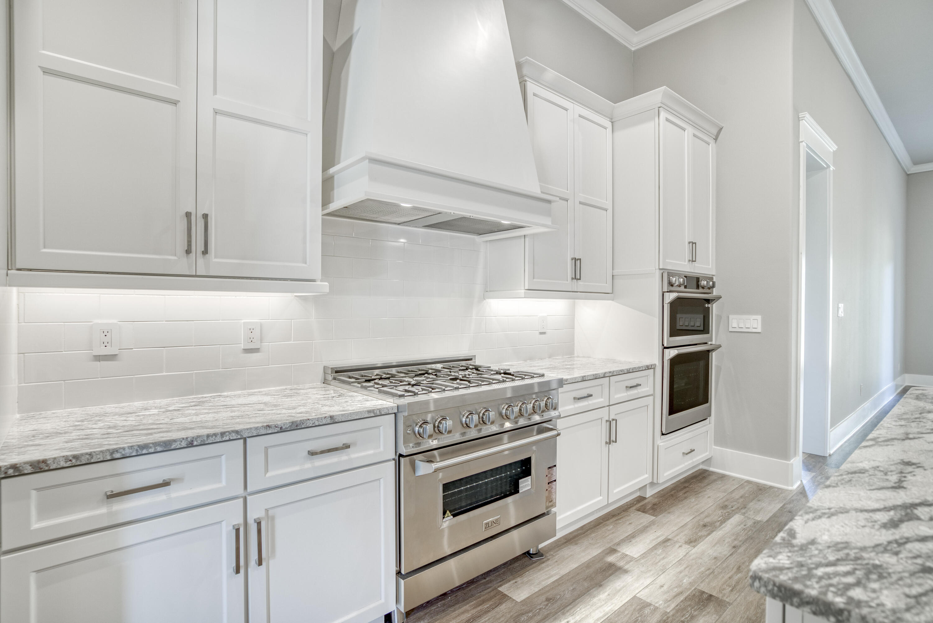 2864 P.G.A Boulevard Navarre, FL 32566 - Photo 9 of 52 a kitchen with granite countertop white cabinets and white appliances
