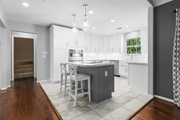 a kitchen with stainless steel appliances kitchen island granite countertop a stove a sink and a refrigerator