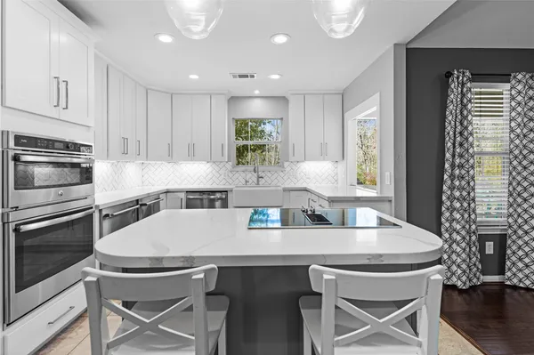 a kitchen with granite countertop a table chairs stove and microwave