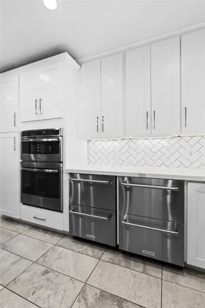 a kitchen with granite countertop a stove top oven microwave and cabinets
