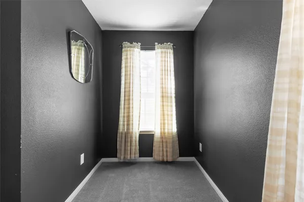 an empty room with windows and mirror