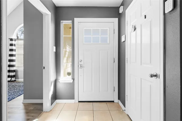 a view of a hallway with wooden floor and a bathroom