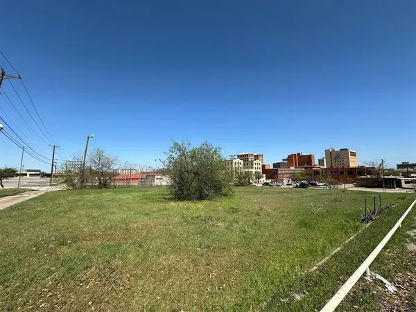 a view of a field with a house in the background
