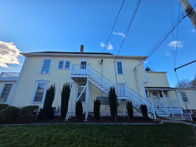 a view of a house with a yard and sitting area