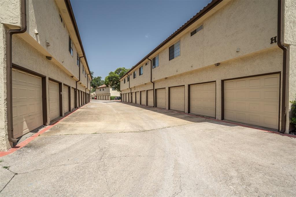 5590 Spring Valley Road, Unit H 203 Dallas, TX 75254 - Photo 27 of 27 Two rows of stucco buildings featuring multiple individual garage doors