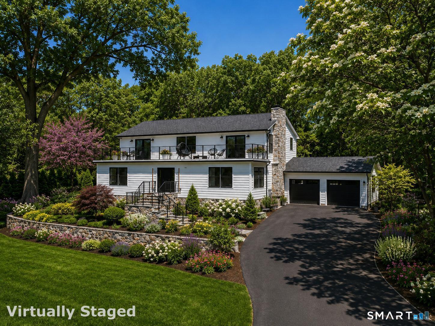 Virtually enhanced. This is an photo of what the front of the house could look like with more mature landscaping added. Additional landscaping to be done by Buyer.