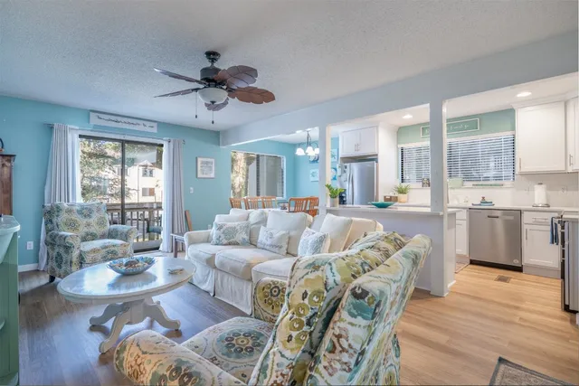 a living room with furniture kitchen and a large window