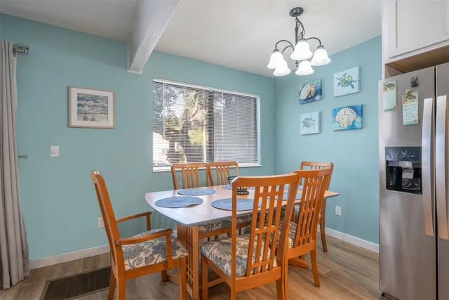 a view of a dining room with furniture a chandelier and wooden floor