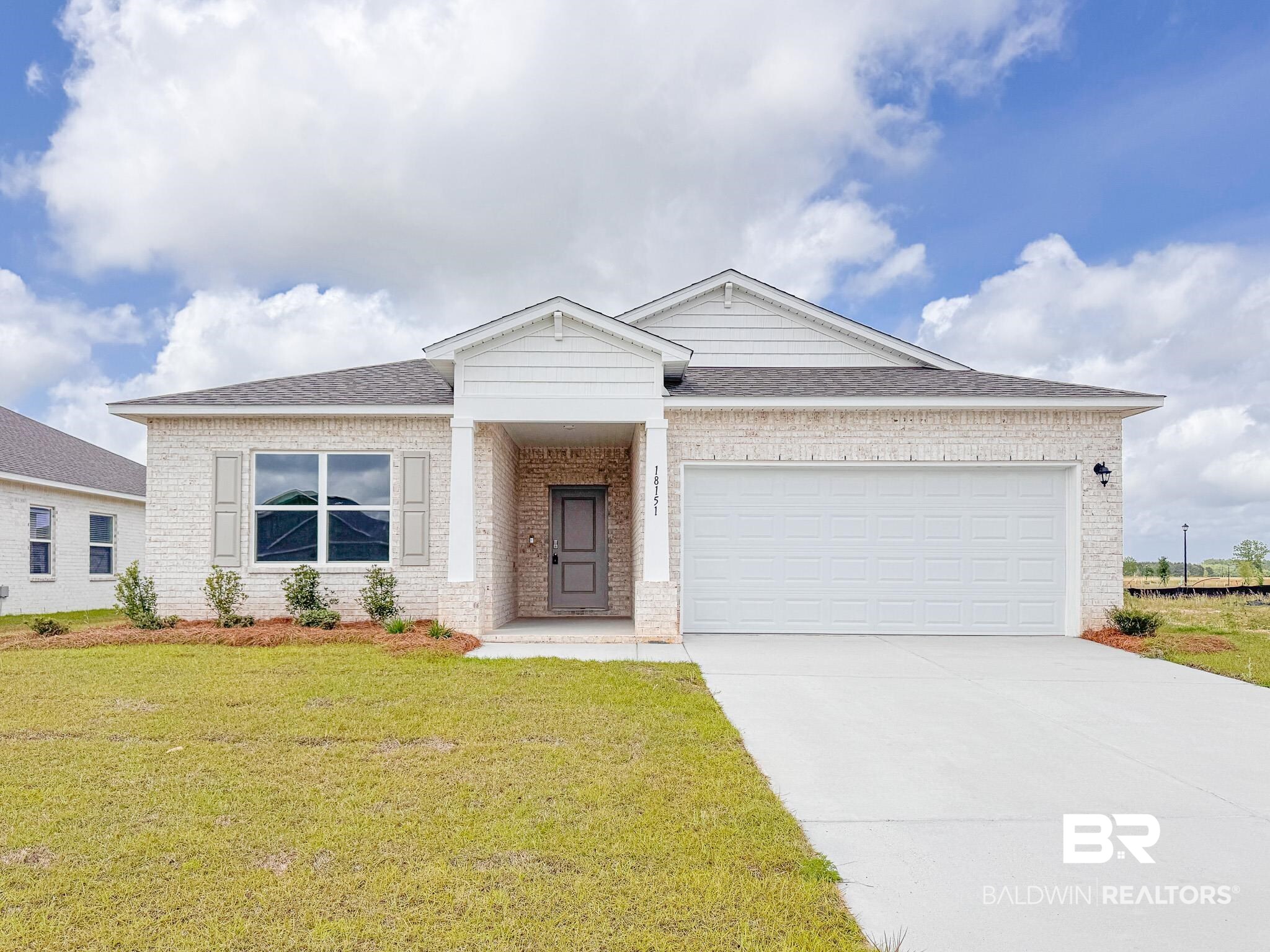 18151 Kent Circle Foley, AL 36535 - Photo 1 of 25 Single-story residence featuring light brick masonry, a two-car garage, a covered entry with columns, and a landscaped front yard with a concrete driveway