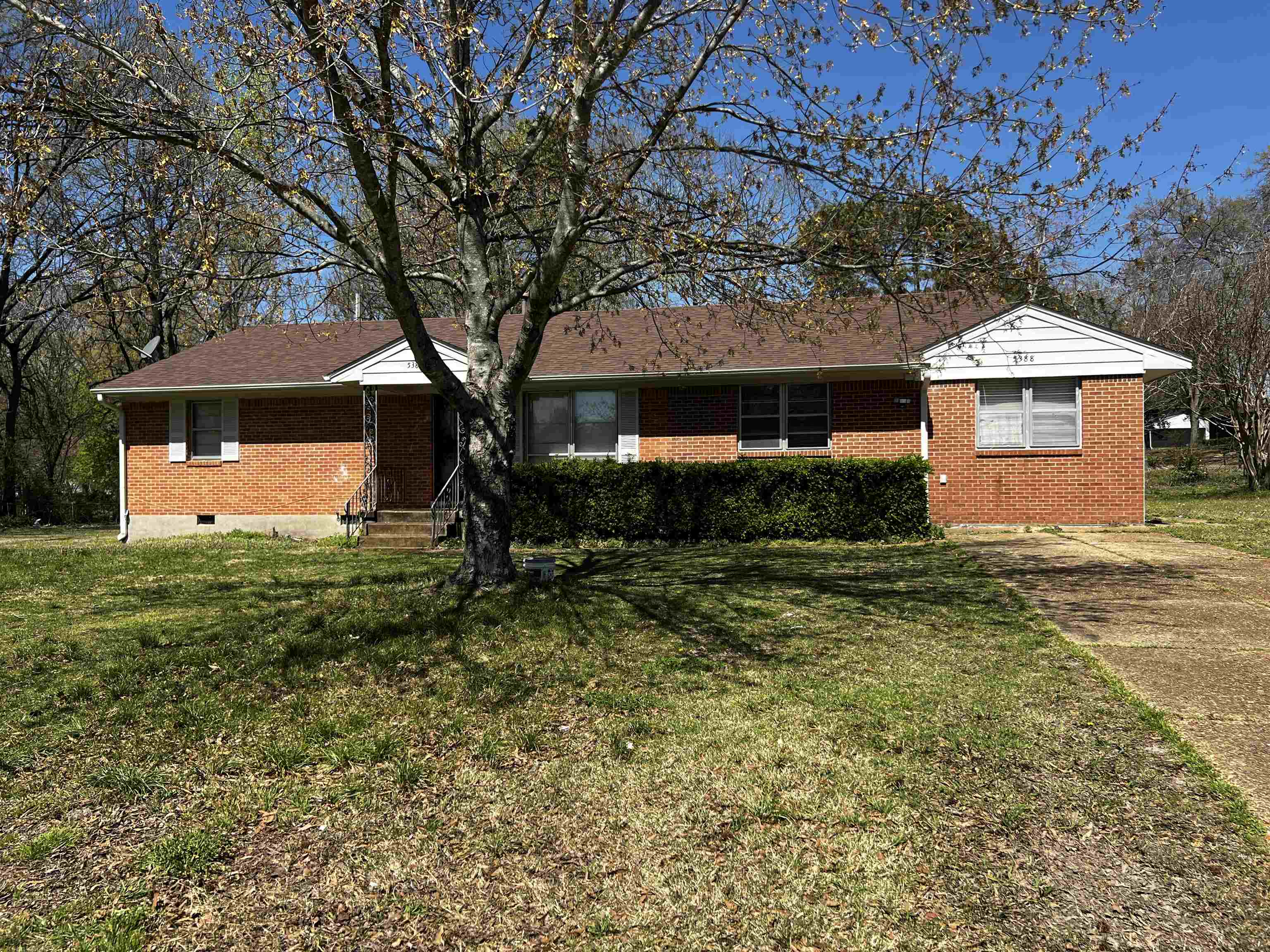 Ranch-style house with a front lawn, brick siding, and concrete driveway