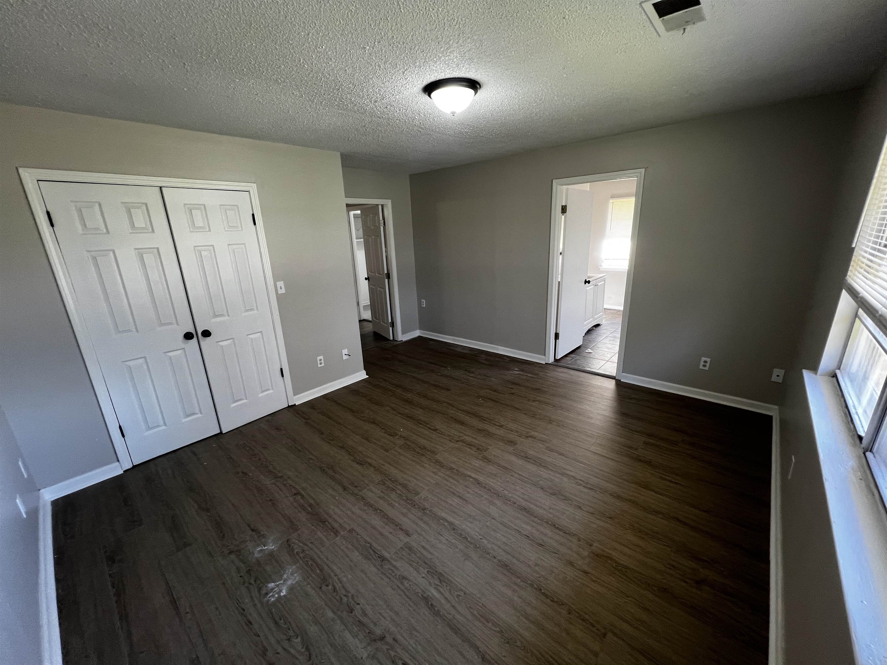 5388 Virgil Road Bartlett, TN 38134 - Photo 11 of 13 Unfurnished bedroom with dark wood-style floors, visible vents, and baseboards