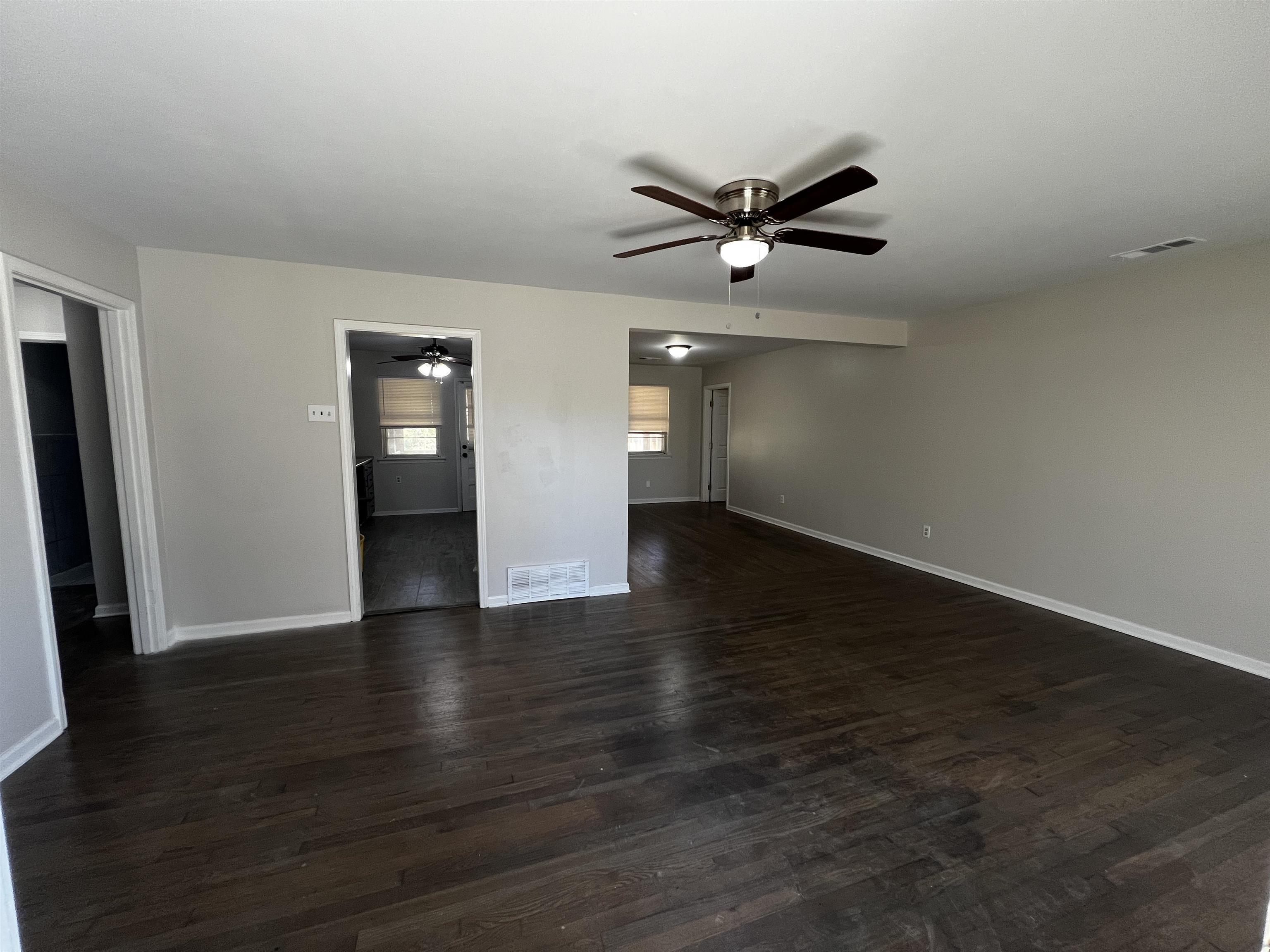 5388 Virgil Road Bartlett, TN 38134 - Photo 3 of 13 Empty room featuring dark wood finished floors, baseboards, visible vents, and ceiling fan