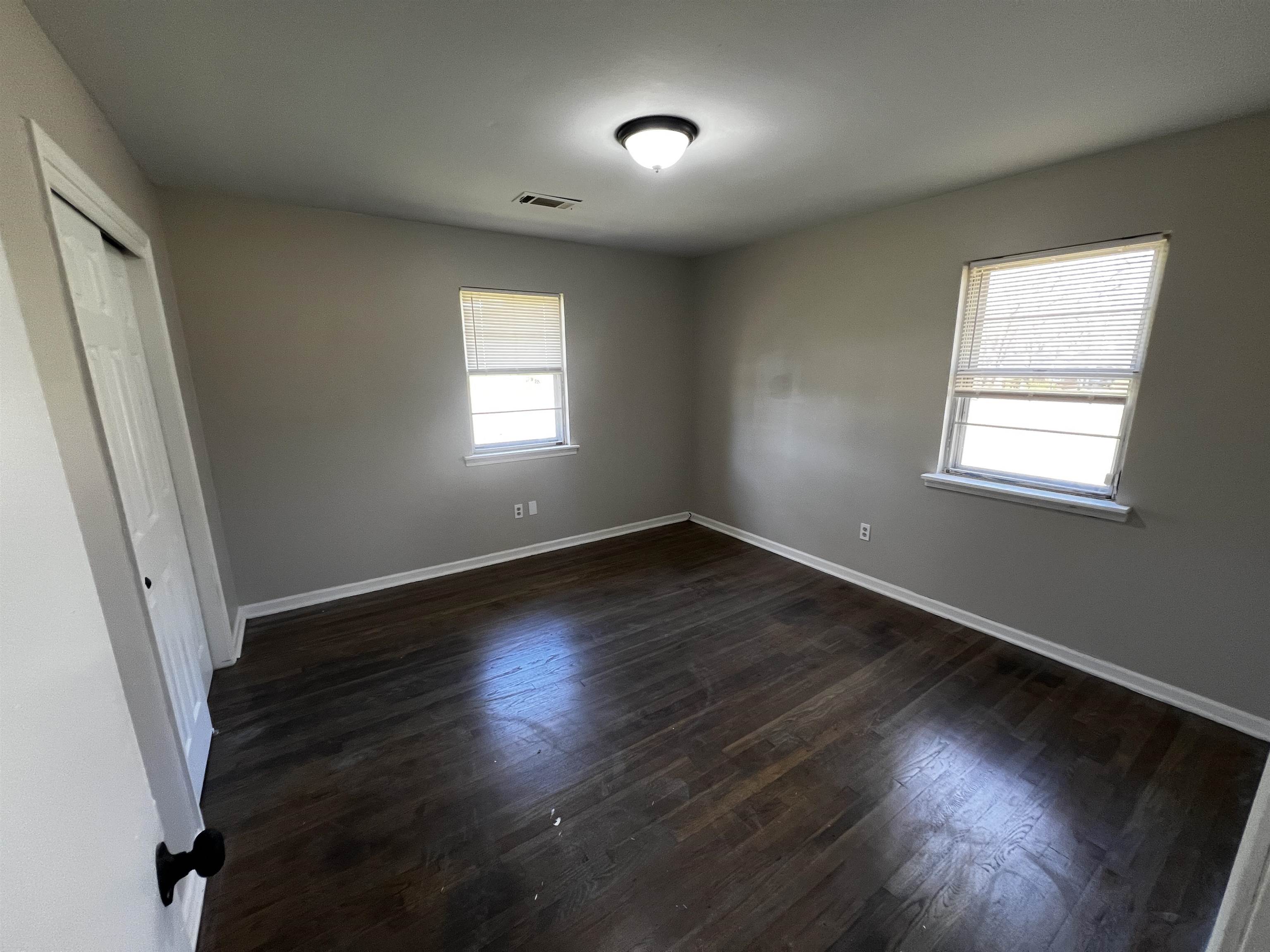 5388 Virgil Road Bartlett, TN 38134 - Photo 5 of 13 Unfurnished bedroom featuring dark wood-style floors, visible vents, a closet, and baseboards