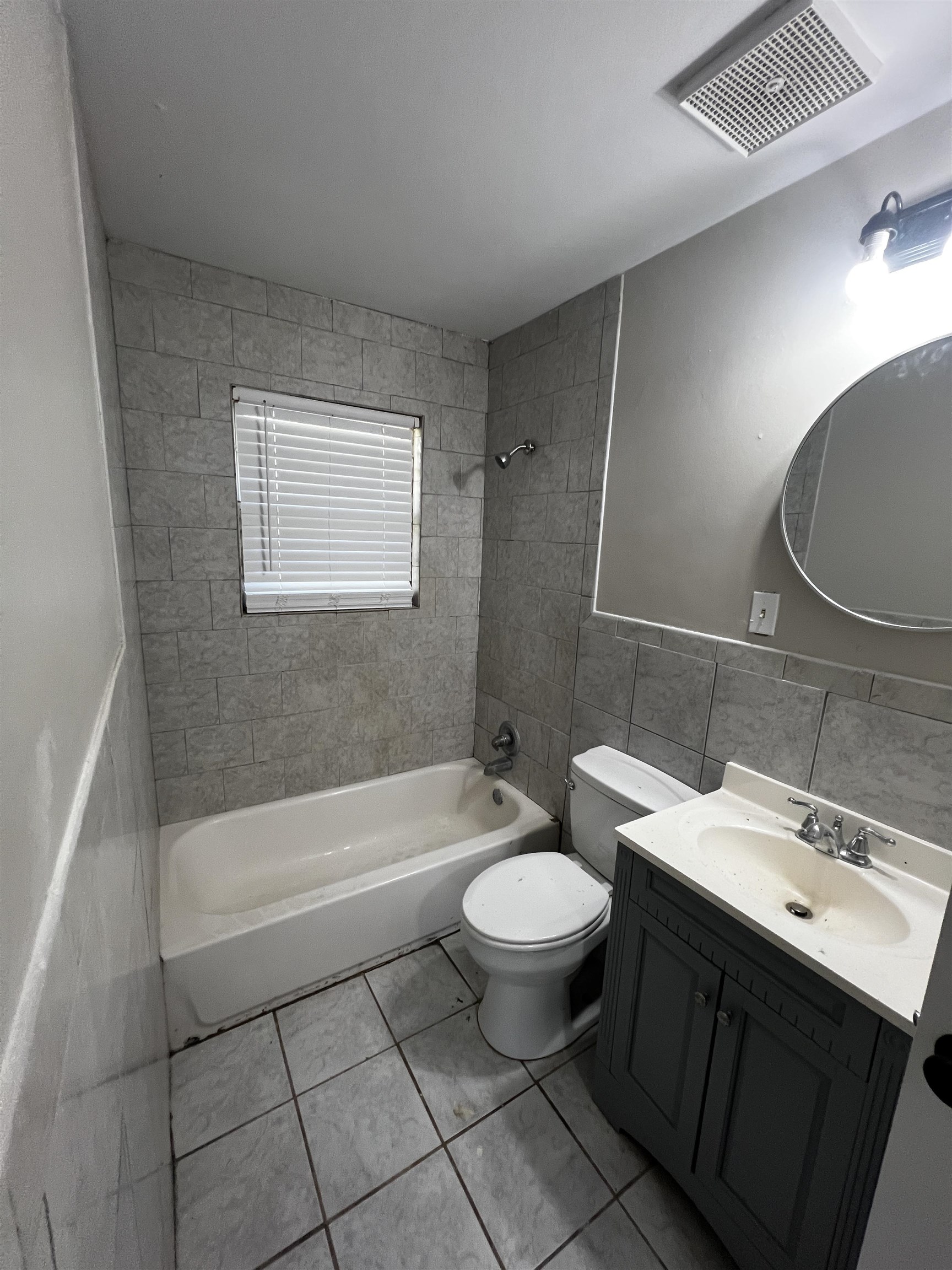 5388 Virgil Road Bartlett, TN 38134 - Photo 10 of 13 Full bath with toilet, vanity, washtub / shower combination, visible vents, and tile walls