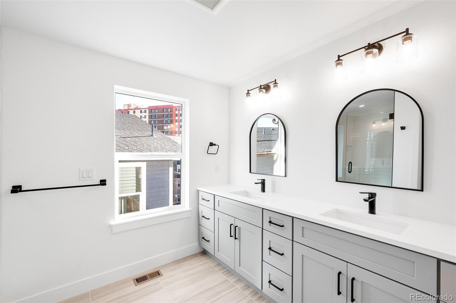4660 West 9th Avenue Denver, CO 80204 - Photo 15 of 35 a bathroom with double vanity a sink a mirror a vanity and a window