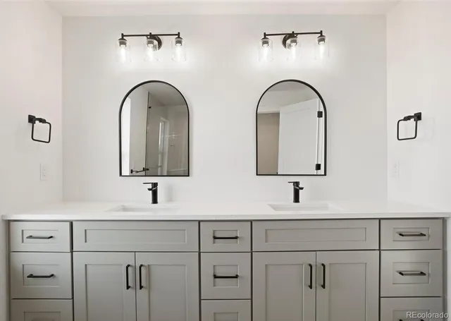 a bathroom with double vanity sinks and a mirror
