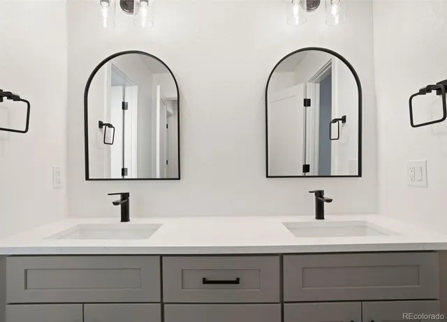 a bathroom with a double vanity sink and two mirror