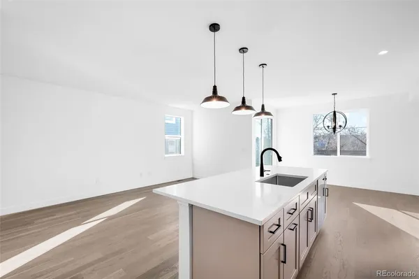 a kitchen with stainless steel appliances a sink a stove and a wooden floors
