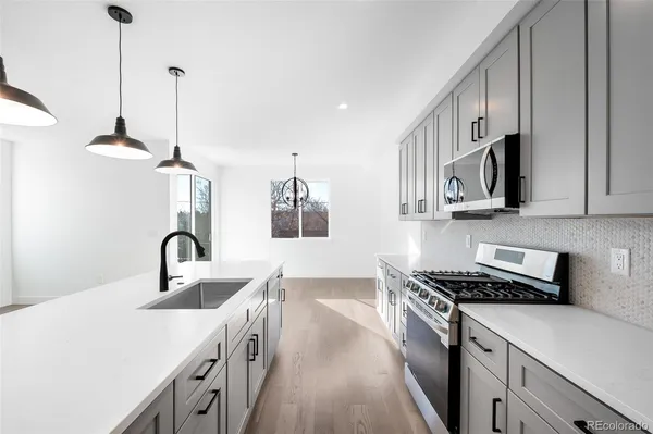 a view of a hallway with wooden floor and a chandelier